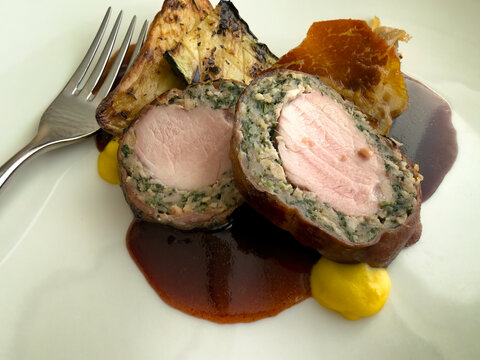 Beef steak meat rolls served with bacon and fried vegetables on white plate dish