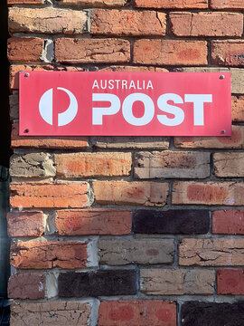 Australian Post Office Sign on Brick Wall with Iconic Red Branding