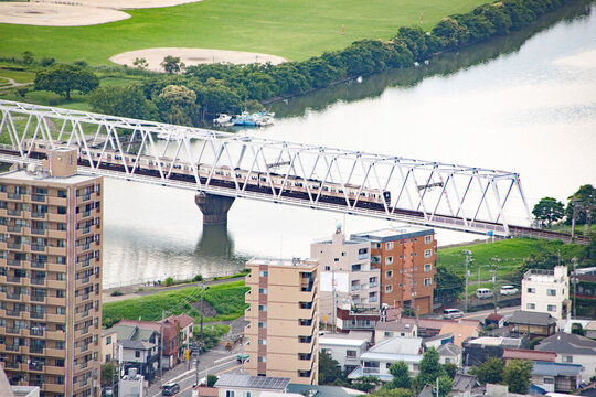 Train Crossing a Bridge Over a River Near a City