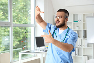Fototapeta premium Male doctor in AR glasses showing something at hospital
