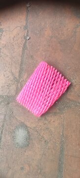 Pink Protective Foam Sleeve for Fruit Packaging Placed on a Weathered Textured Stone Ground