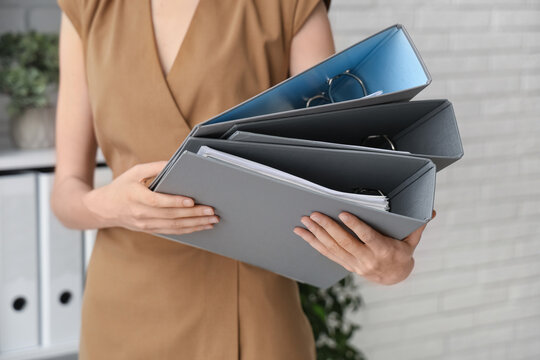 Young woman with folders in office. Closeup