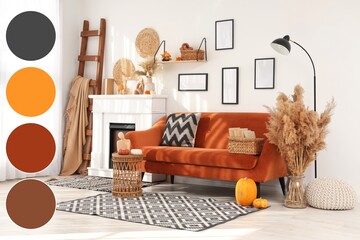 Obraz premium Cozy autumn living room interior with orange sofa fireplace decorative pumpkins and pampas grass for seasonal home decoration