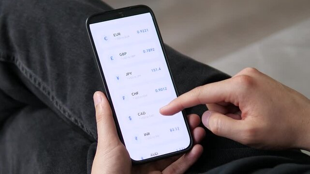 A traveler checking real-time USD conversion rates for CAD, INR, SGD, and JPY. Great for travel finance apps, currency calculators, and international vacation planning marketing.