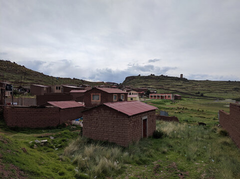 Rural houses in Umayo village with the Sillustani Chullpas in the background, Puno, Peru