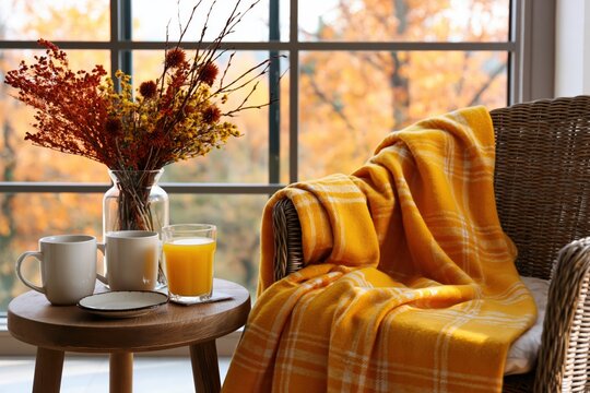 Autumn morning with cozy armchair blanket window coffee and orange juice at home