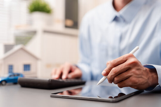 Digital signature and asset management concept. Man signing on tablet.