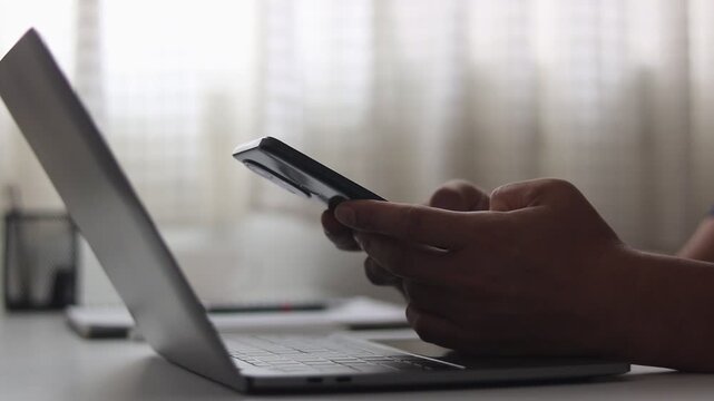Mobile cybersecurity concept with person using smartphone beside a laptop, representing secure authentication, password protection, online banking, data privacy, digital identity and cyber security.