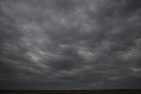 Heavy, overcast sky at dusk with thick gray clouds blocking the sun.