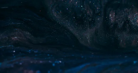 Dark ink flow. Defocused sparkling texture. Black blue night color dye blending in glitter cosmic liquid wavy abstract background. © golubovy