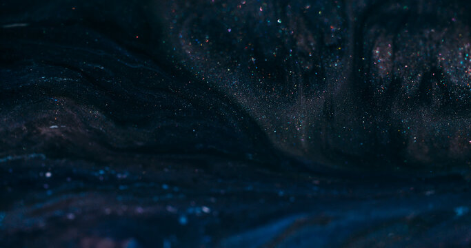 Dark ink flow. Defocused sparkling texture. Black blue night color dye blending in glitter cosmic liquid wavy abstract background.
