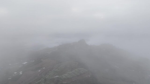 Cinematic Aerial Forward Flight Emerging from Dense Fog to Reveal Mountain Vegetable Fields and a Sea of Clouds in Atok
