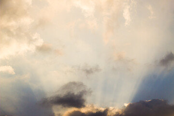 Obraz premium Beautiful crepuscular sun rays breaking through dramatic clouds at sunset sky.