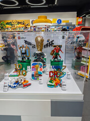 Obraz premium Display case at LEGO store featuring FIFA World Cup brick figures of Messi and Ronaldo with trophy in Shanghai, China - May 25, 2026