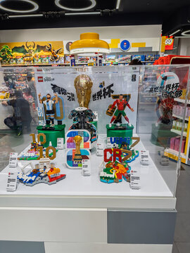 Display case at LEGO store featuring FIFA World Cup brick figures of Messi and Ronaldo with trophy in Shanghai, China - May 25, 2026