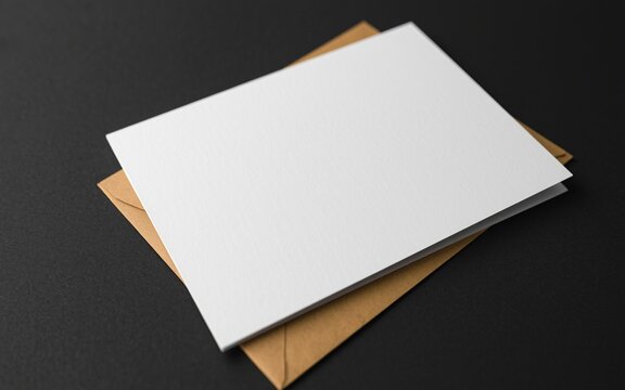 One A7 folded card, one manila envelope, a dark surface, and a dark background.