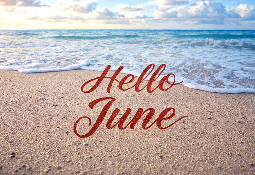 Beautiful beach scene with hello june written elegantly in the sand by the waves