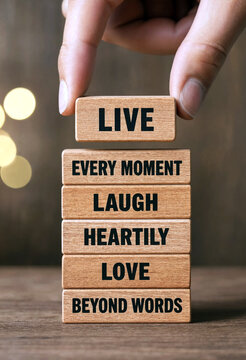 Hand placing wooden block with motivational message about living laughing and loving beyond words