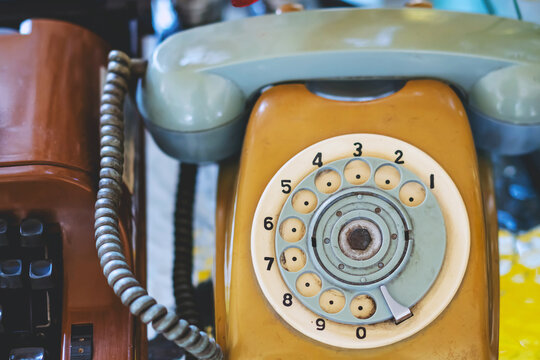 Vintage rotary dial telephone wheel. Circular rotary dial wheel with numbers from 1 to 0 of an antique beige telephone. Nostalgic details and retro textures of analog communication technology concept.