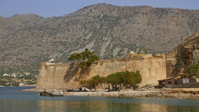 Old fortress on the coast, surrounded by trees and water, with hilly landscape in the background, Venetian Sea Fortress, Leper Island, Spinalonga, Elounda Bay, Mirabello Bay, East Crete, Crete, Greek Islands, Greece