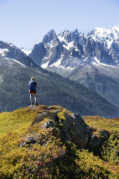 Hiker looking at mountain panorama from Aiguillette des Posettes, Aiguille du Midi and Mont Blanc, Chamonix, Haute-Savoie, France