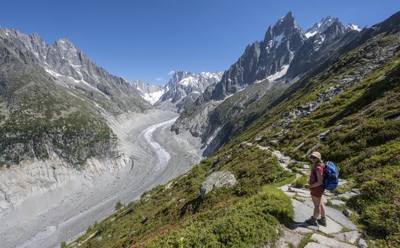 Climber on hiking trail, Grand Balcon Nord, glacier tongue Mer de Glace, behind Grandes Jorasses, Mont Blanc massif, Chamonix, France
