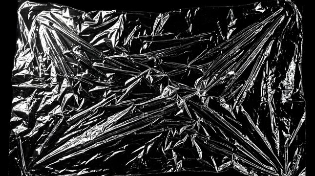 Crinkled transparent plastic wrap texture with light reflections on black