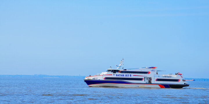 BATAM, INDONESIA - MARCH 15, 2026: high-speed passenger ferry boat sailing across blue ocean waters in the Riau Islands region. This fast ferry operates inter-island maritime tran
