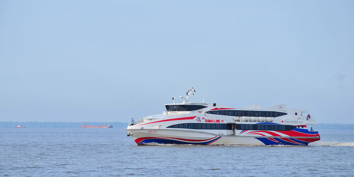 BATAM, INDONESIA - MARCH 15, 2026: high-speed passenger ferry boat sailing across blue ocean waters in the Riau Islands region. This fast ferry operates inter-island maritime tran