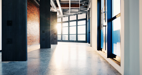 Obraz premium Modern, empty or flare in office for business, corridor or corporate interior in professional space. Vacant, contemporary passage or lobby with sunshine, spacious setting or glass windows in agency.
