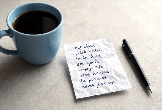Handwritten motivational note with coffee cup and pen on table for daily inspiration and productivity boost