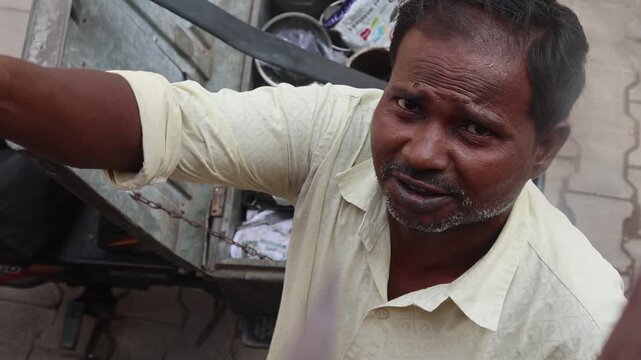 Indian village man repairing a frying pan handle with a screwdriver outdoors, showcasing traditional cookware repair, manual craftsmanship, and sustainable everyday living in rural India.