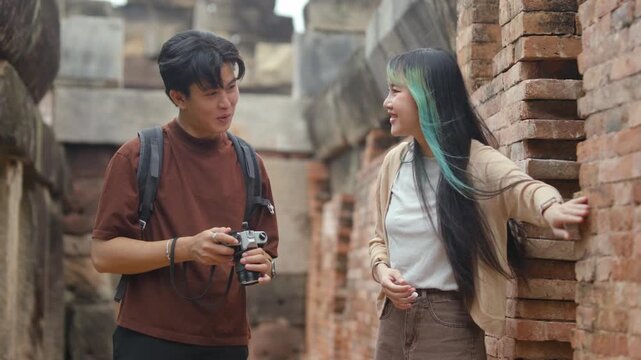 Young Asian Couple Discovering Historic Temple Architecture During Cultural Heritage Journey