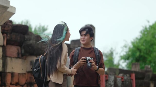 Young Asian Travelers Reviewing Camera Settings While Exploring Ancient Ruins, Authentic Travel Lifestyle Video