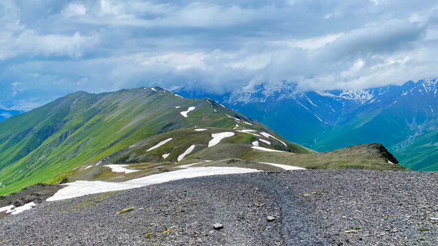 Views from Chaukhi Pass above 3300 meters reveal snow-streaked ridges and cloud-covered valleys in Georgia