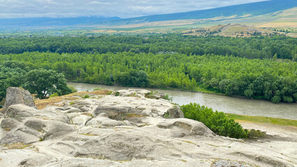 Kura River flows below Uplistsikhe through dense floodplain woodland and farmland in Georgia, presenting watershed geography © chekart