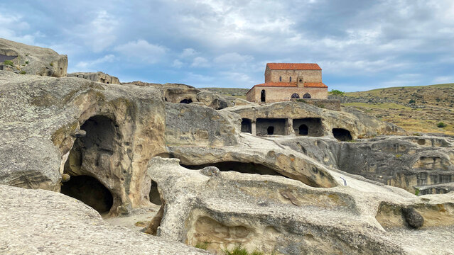 Medieval basilica rises above Uplistsikhe caves in Georgia, presenting layered history from an ancient rock city