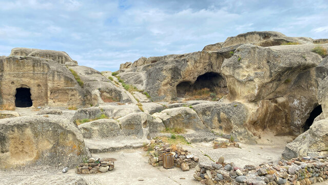 Camera surveys Uplistsikhe caves in wide view, revealing rock-cut chambers and ancient passages in Georgia