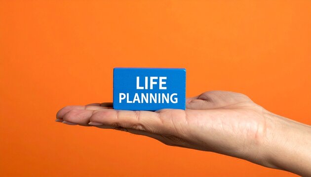 Hand holding LIFE PLANNING block against bright orange background