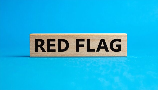 Wooden block with RED FLAG text against bright blue background