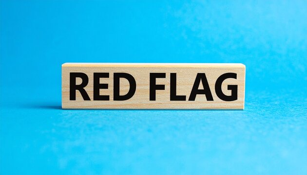 Wooden block with RED FLAG text against bright blue background