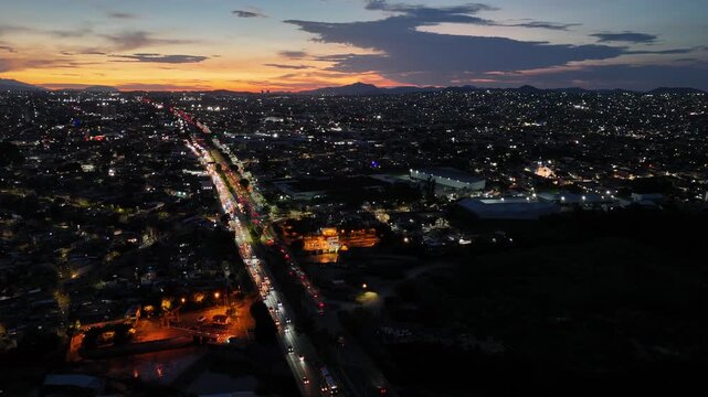 Tr&aacute;fico en Perif&eacute;rico Norte de Guadalajara Jalisco M&eacute;xico y atardecer de fondo 
