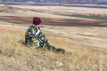 A male tourist sits on a hill on a sunny spring day © tramp51
