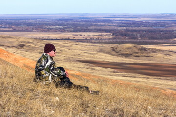 A male tourist sits on a hill on a sunny spring day © tramp51
