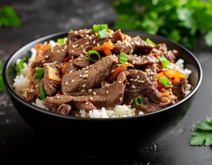 Fototapeta premium Savory Korean beef bulgogi bowl served over white rice with sesame seeds and green onions on a dark table, featuring traditional Asian flavors