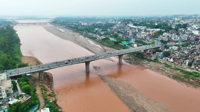 Aerial drone of Tawi bridge during rainy season Jammu, showing mixed slum and apartment housing on flood vulnerable banks