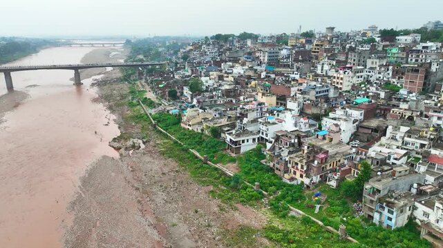 Monsoon Tawi River aerial over Jammu city bridges, flood prone housing and poor urban planning along the banks