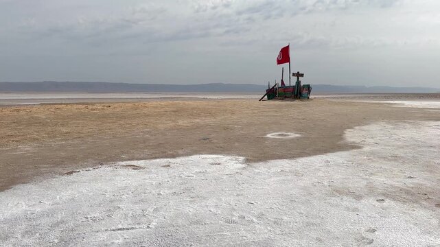 Ship-shaped wooden platform with a Tunisian flag at Chott el Djerid Desert Lake in Tunisia.