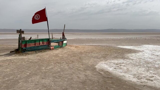Ship-shaped wooden platform with a Tunisian flag at Chott el Djerid Desert Lake, Tunisia.