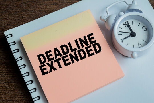 Concept of deadline extended write on sticky notes isolated on Wooden Table.